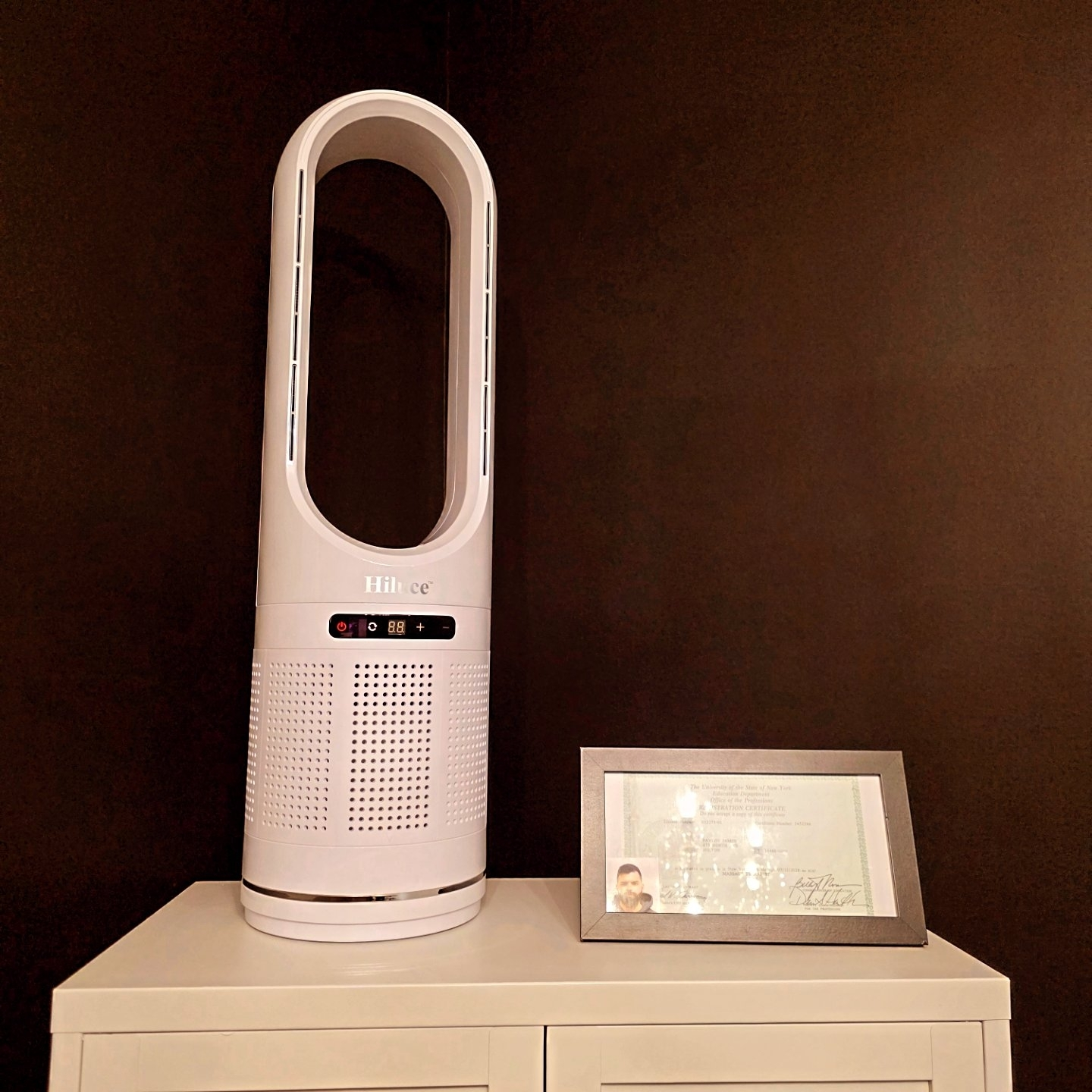 Close-up of HEPA air purifier beside licensure certificate