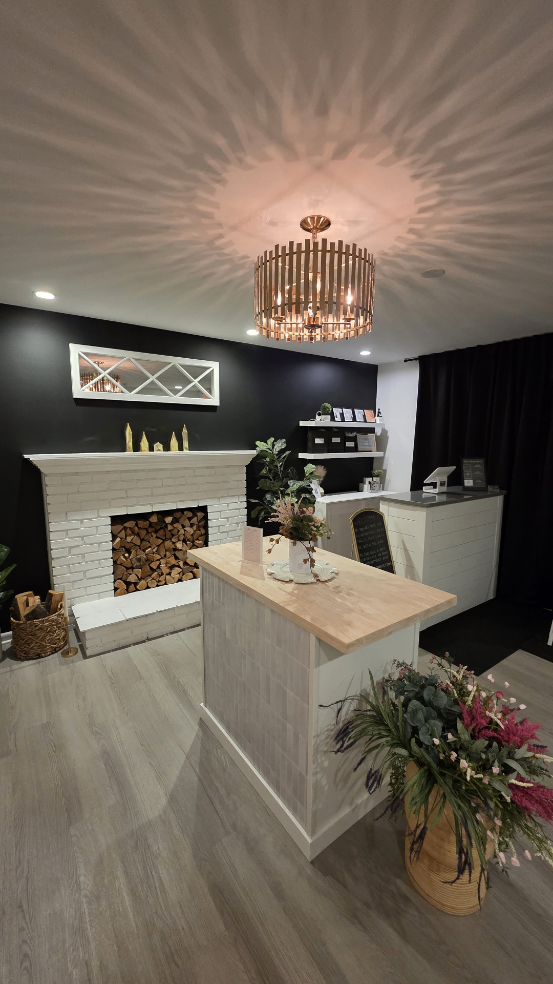 Pavlov Massage reception area with white brick fireplace and chandelier